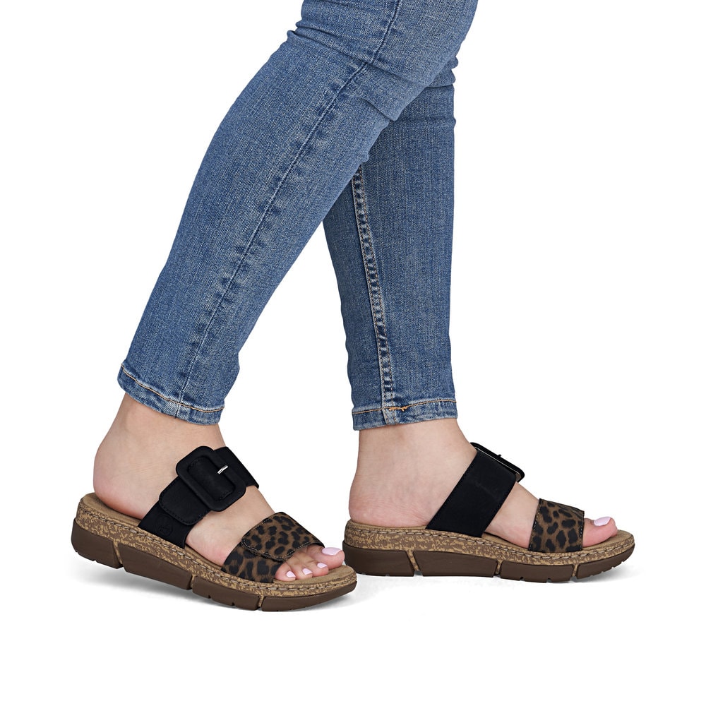 Dunkelbraune Rieker Damen Pantoletten V2392-24 mit angesagtem Animal-Print. Schuh am Fuß.