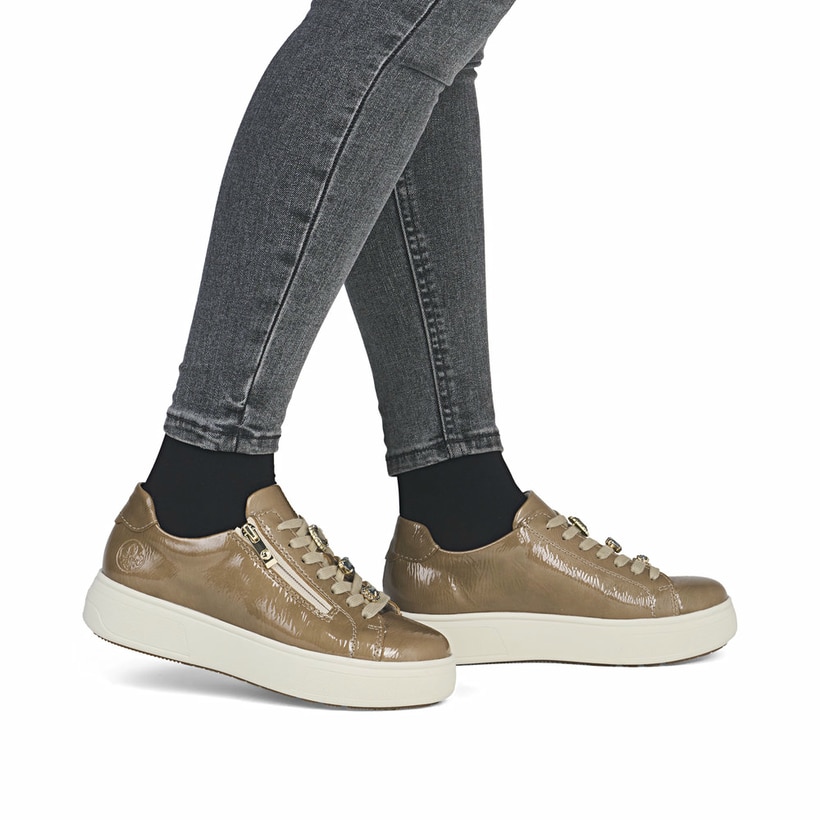 Dunkelbeige Rieker Damen Sneaker Low M7702-64 mit einem Reißverschluss. Schuh am Fuß.
