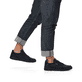 Schwarze Rieker Herren Sneaker Low 07101-00 mit einer flexiblen Sohle. Schuh am Fuß.
