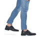 Schwarze Rieker Herren Slipper B0853-00 mit Klettverschluss sowie Extraweite H. Schuh am Fuß.