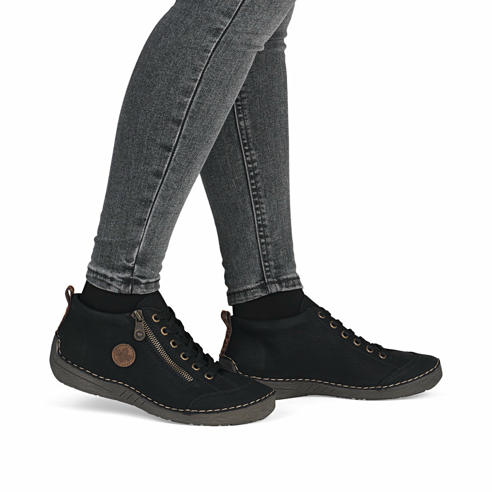 Schwarze Rieker Damen Schnürstiefel 52514-00 mit rundem Logo. Schuh am Fuß.