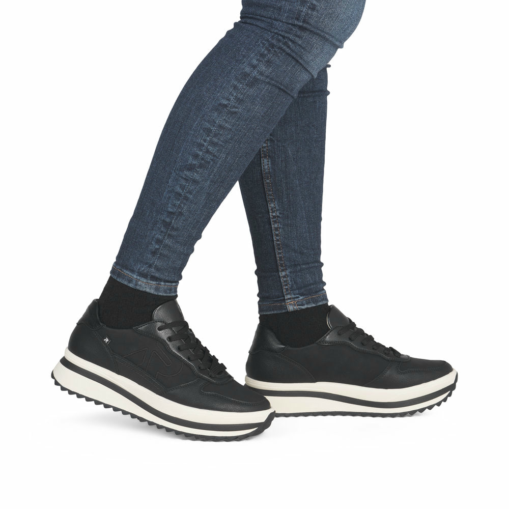 Schwarze Rieker Damen Sneaker Low W3800-00 aus Glattleder mit einer Schnürung. Schuh am Fuß.