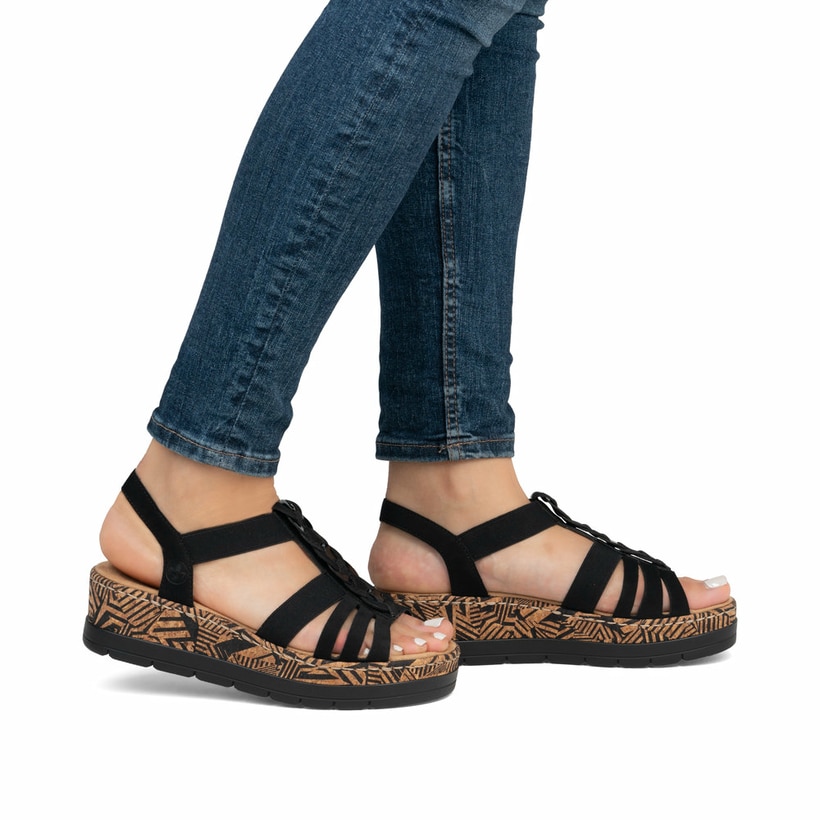 Schwarze Rieker Keilsandaletten V3902-00 mit einem Gummizug. Schuh am Fuß.