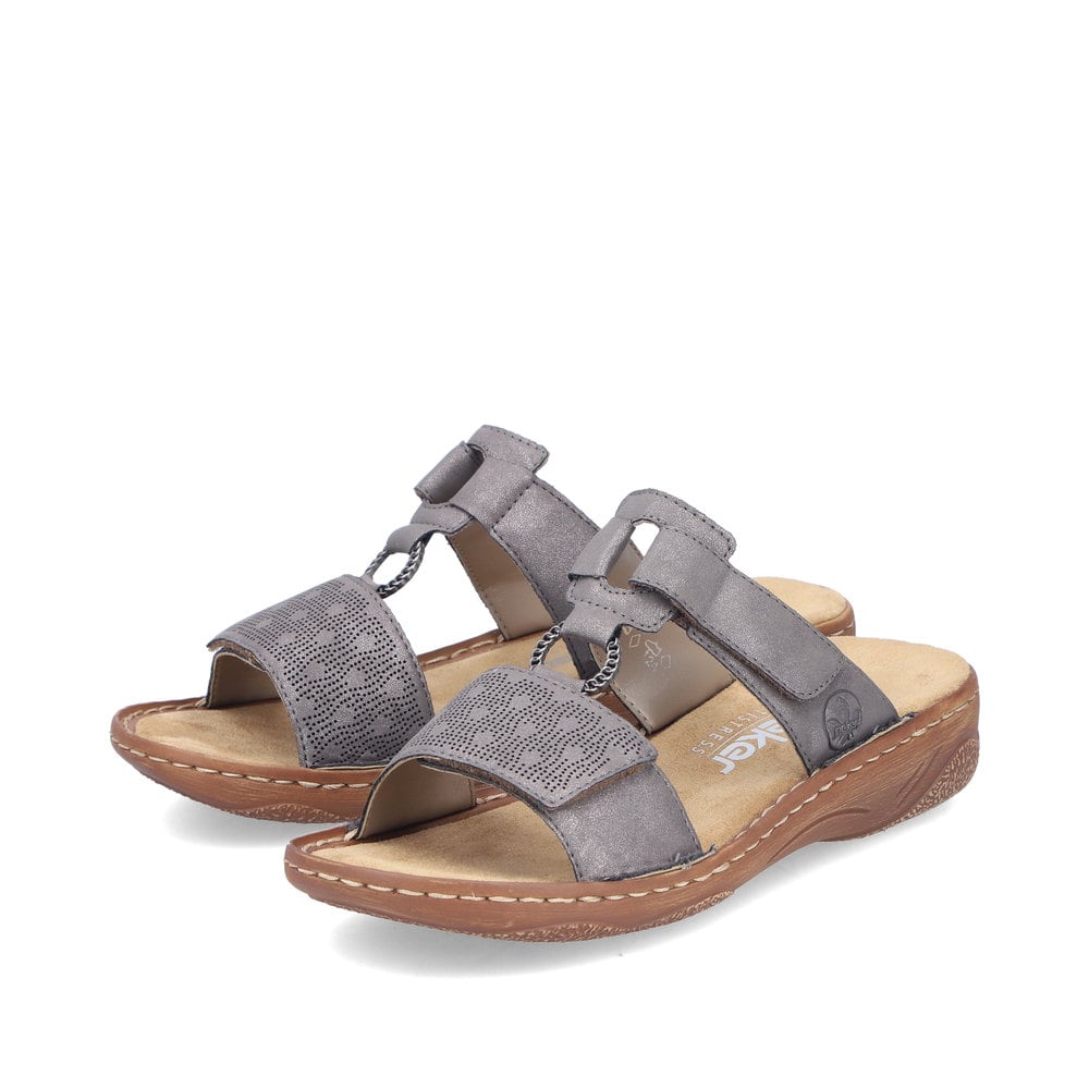 Graue Rieker Damen Pantoletten V2885-42 in Löcheroptik mit einem Klettverschluss. Schuhpaar seitlich schräg.
