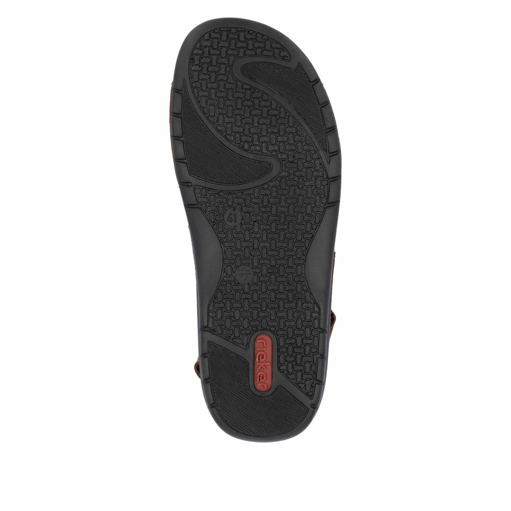 Mules Rieker marron homme 25559-25 en cuir velours avec fermeture velcro. Semelle extérieure de la chaussure.