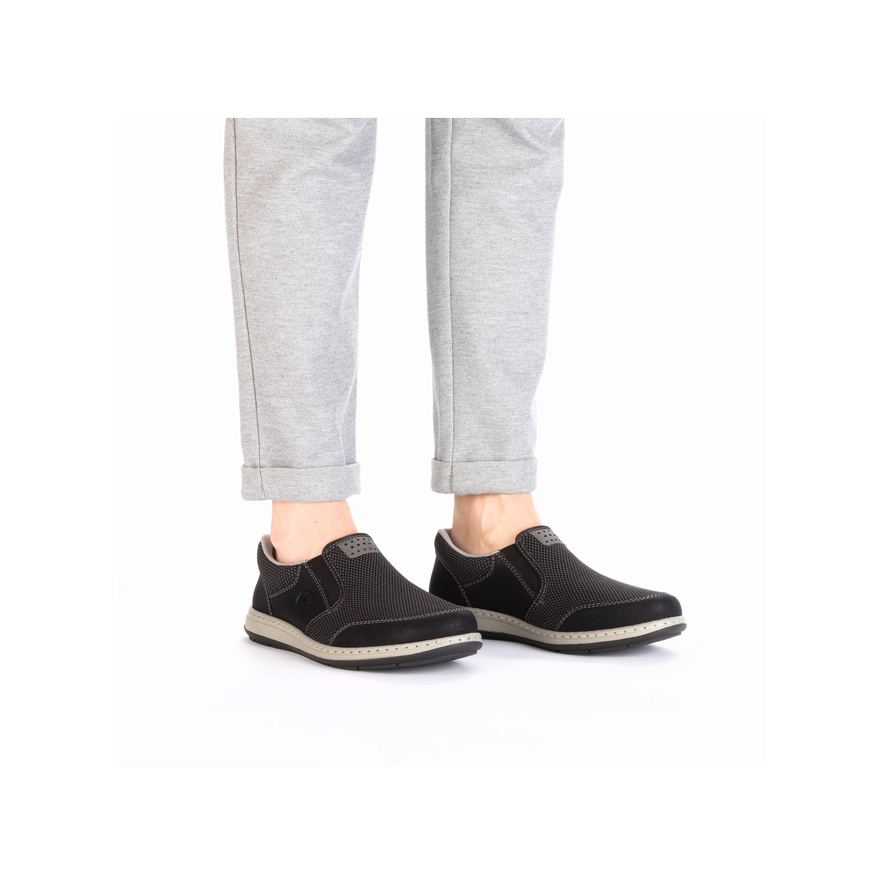 Schwarze Rieker Herren Slipper 17363-00 mit einem Gummizug sowie Extraweite H. Schuh am Fuß.