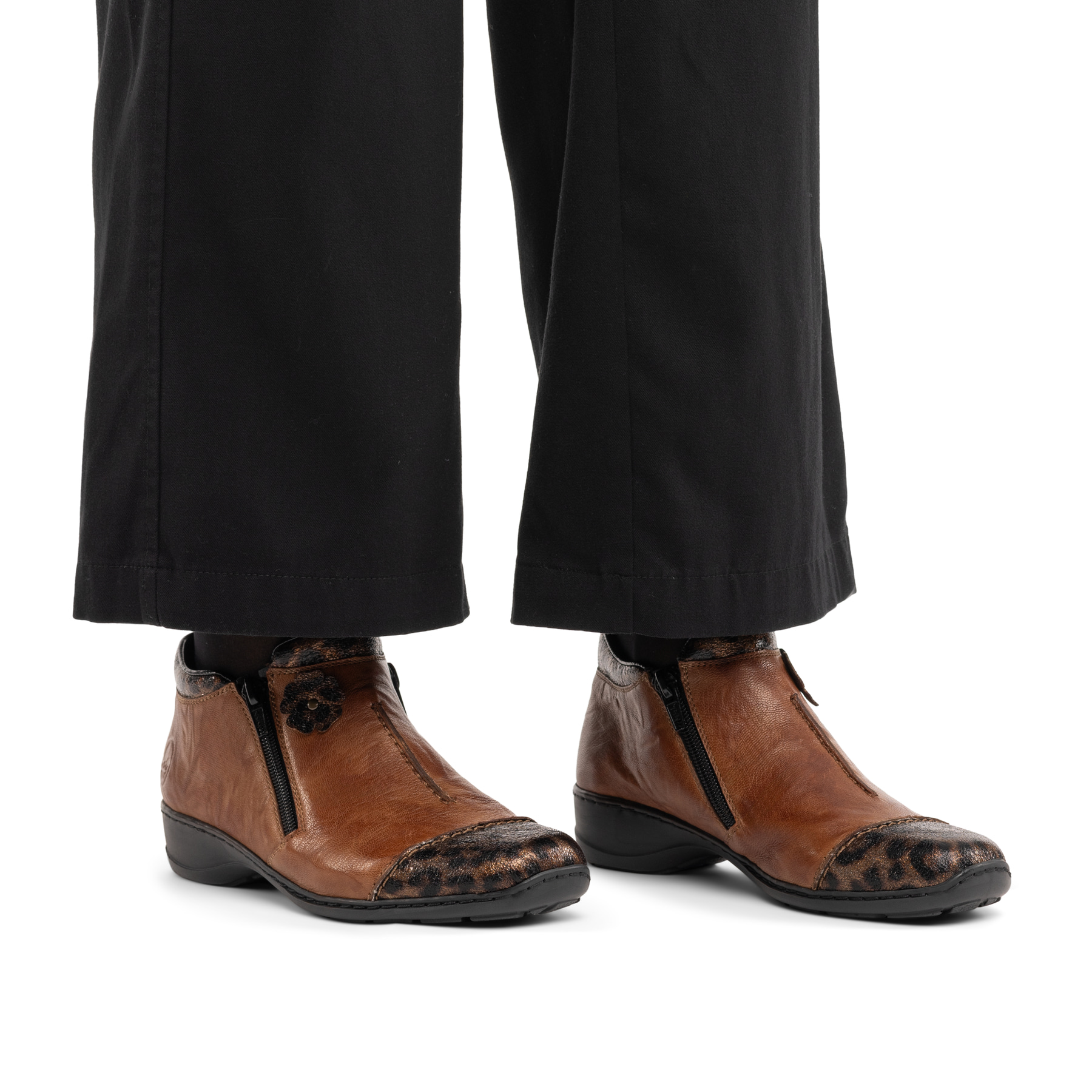 Braune Rieker Damen Kurzstiefel 58388-23 aus Glattleder mit dekorativer Blume. Schuh am Fuß.