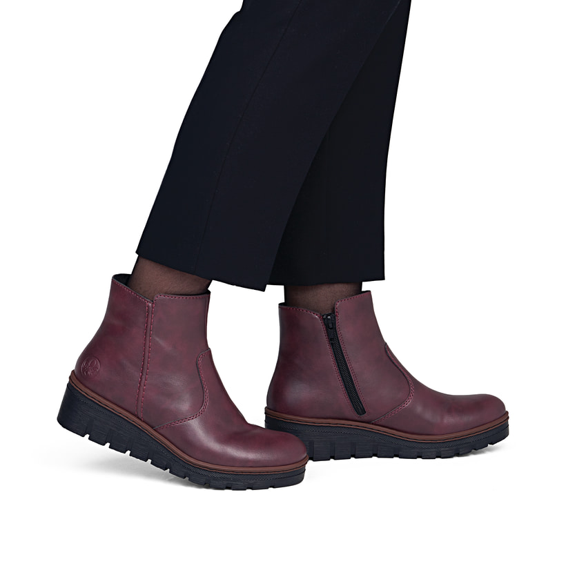 Weinrote Rieker Damen Kurzstiefel X9165-35 mit einem Reißverschluss. Schuh am Fuß.