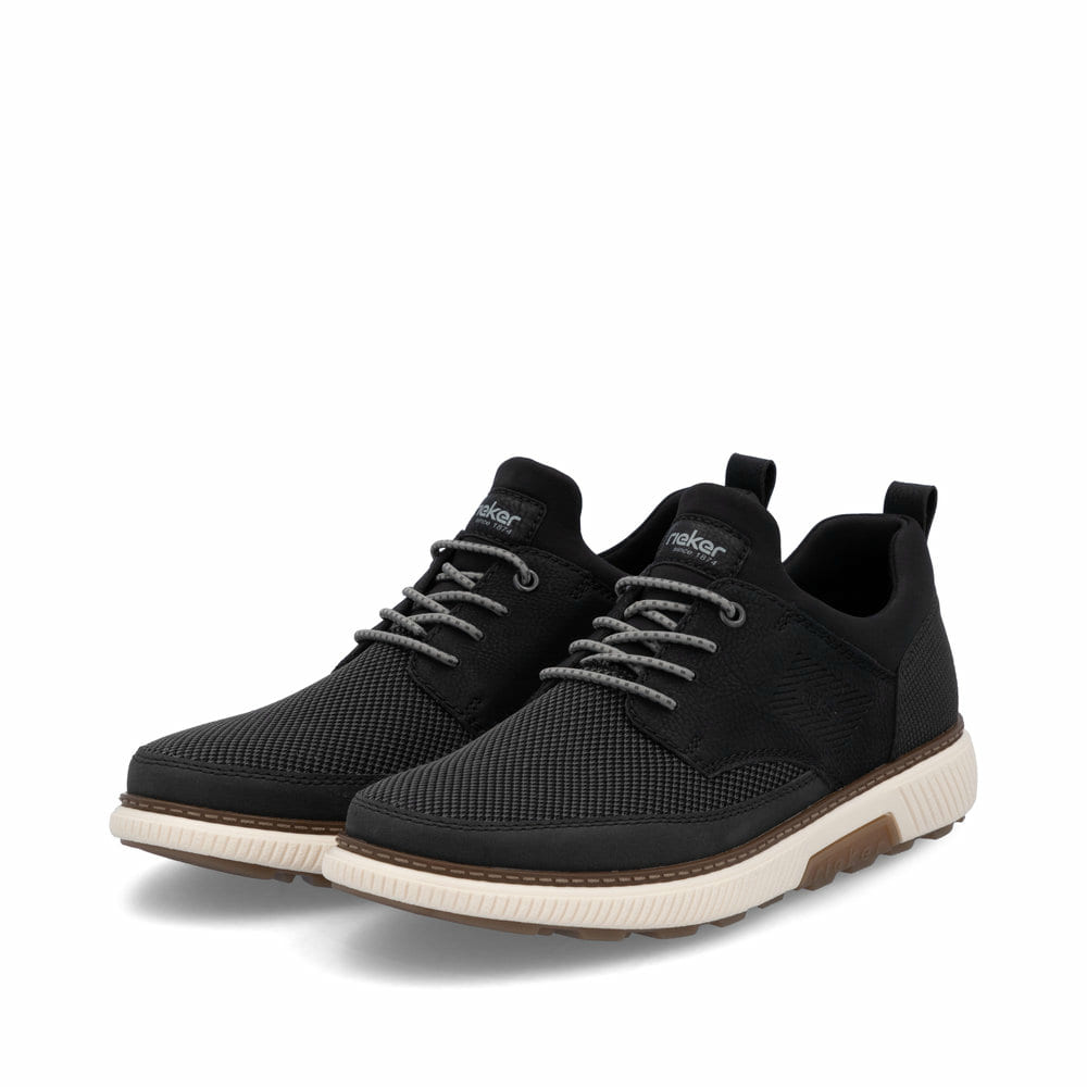 Schwarze Rieker Herren Slipper B3354-00 mit einem Gummizug sowie Extraweite H. Schuhpaar seitlich schräg.