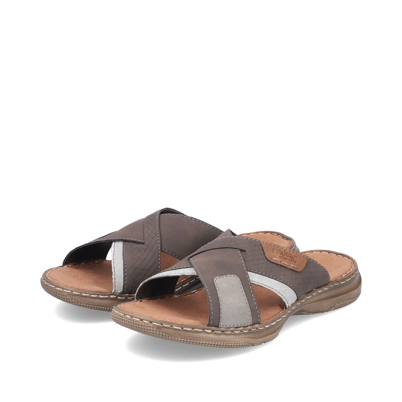 Braune Rieker Herren Pantoletten 21491-25 mit der Komfortweite G 1/2. Schuhpaar seitlich schräg.