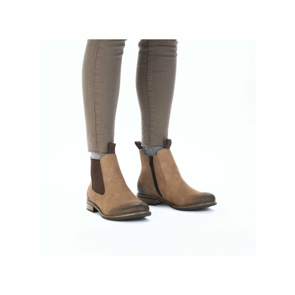 Braune Rieker Damen Chelsea Boots 74878-25 aus Glattleder mit Reißverschluss. Schuh am Fuß.