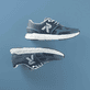 Blaue Rieker Damen Sneaker Low M9000-12 mit Gummischnürung sowie flexibler Sohle. Schuhpaar seitlich liegend auf blauem Hintergrund.