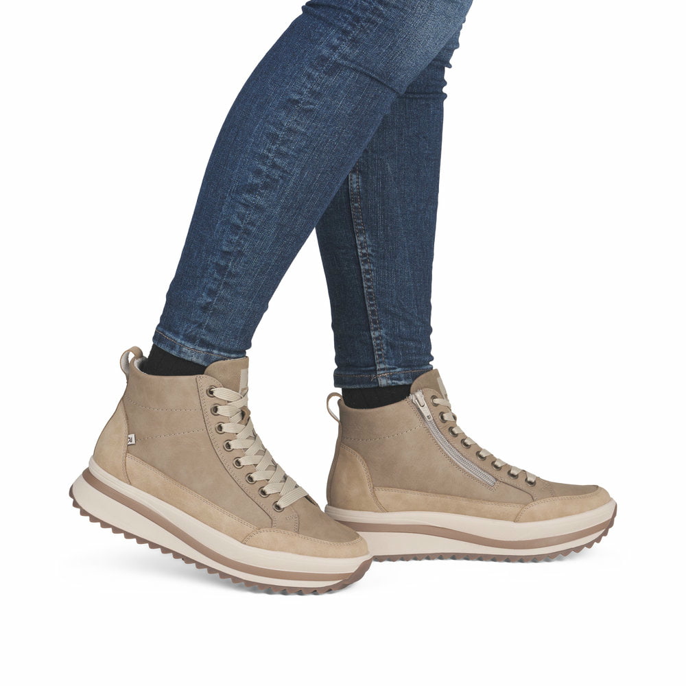 Beige Rieker Damen Schnürstiefel W3871-60 mit einem Reißverschluss. Schuh am Fuß.