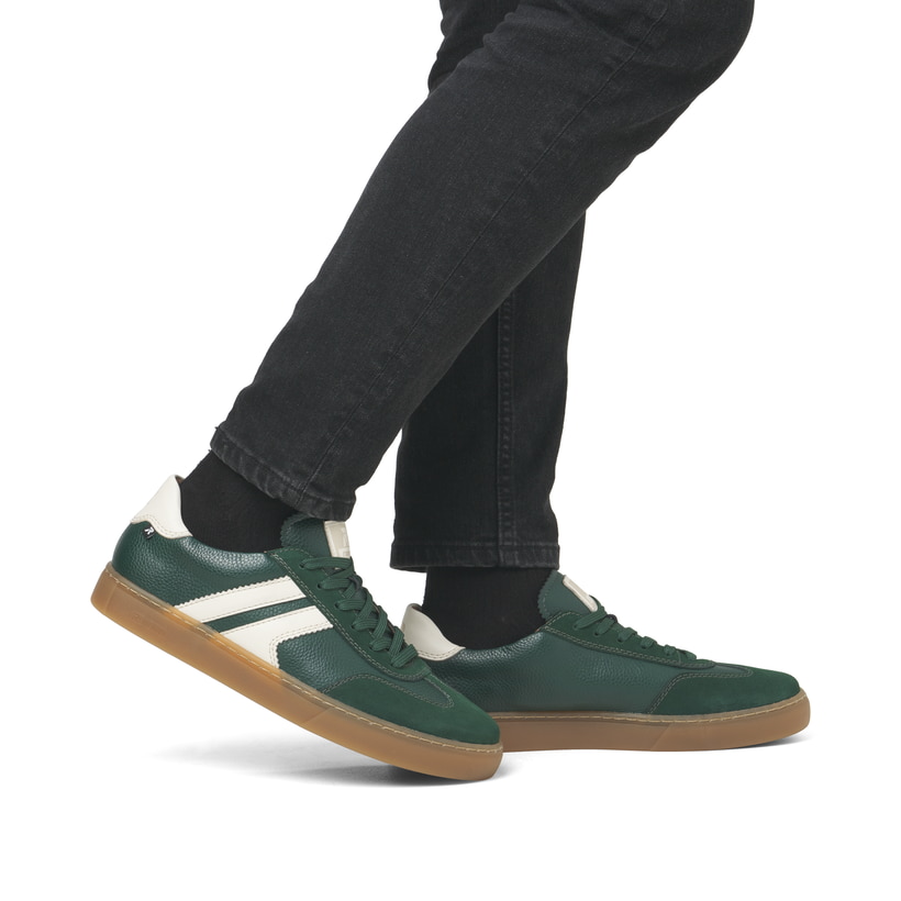 Grüne Rieker Herren Sneaker Low U0707-54 im Retro-Look mit weißen Streifen an der Seite sowie einer Schnürung. Schuh am Fuß.