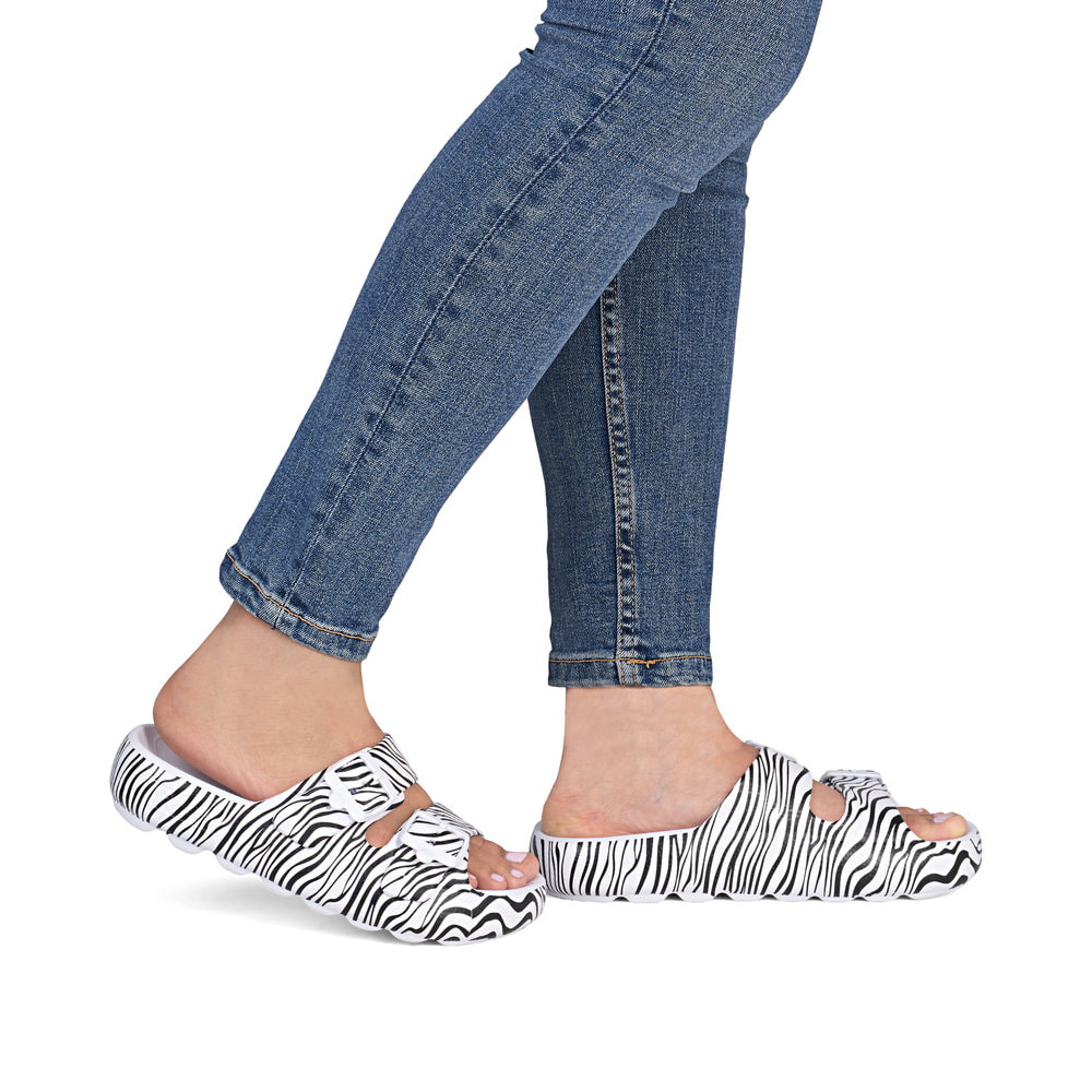 Schwarzweiße Rieker Damen Pantoletten P2450-81 mit angesagtem Animal-Print. Schuh am Fuß.
