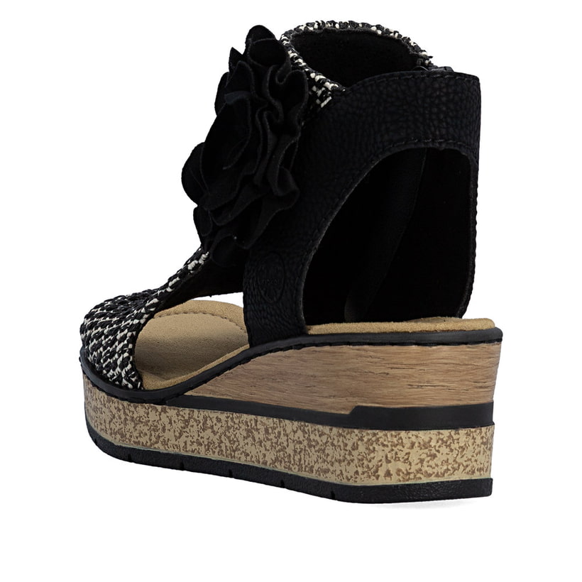 Schwarze Rieker Keilsandaletten 63791-01 mit dekorativer Blume. Schuh von hinten.