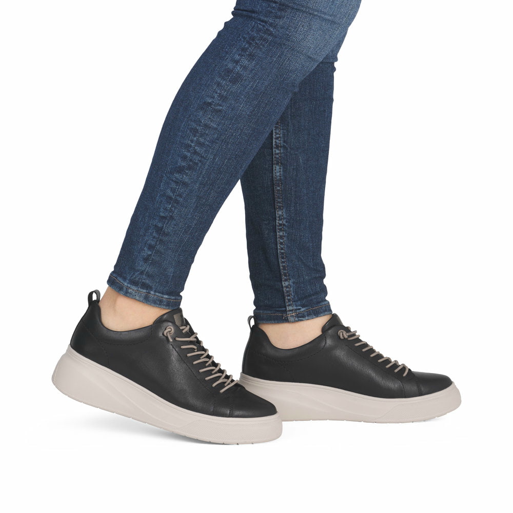 Schwarze Rieker Damen Sneaker Low W2301-00 aus Glattleder mit einer Schnürung. Schuh am Fuß.