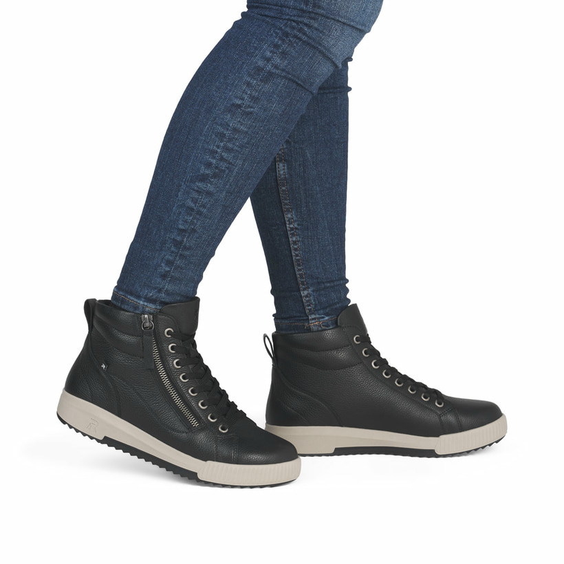 Schwarze Rieker Damen Sneaker High W0164-00 mit leichter und griffiger Sohle. Schuh am Fuß.