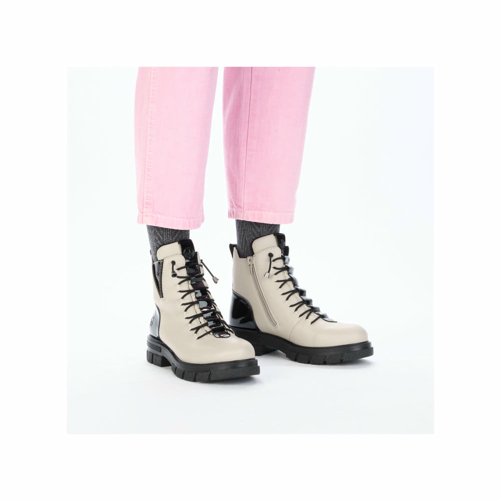 Beigeschwarze Rieker Damen Biker Boots Z9152-60 mit einem Reißverschluss. Schuh am Fuß.