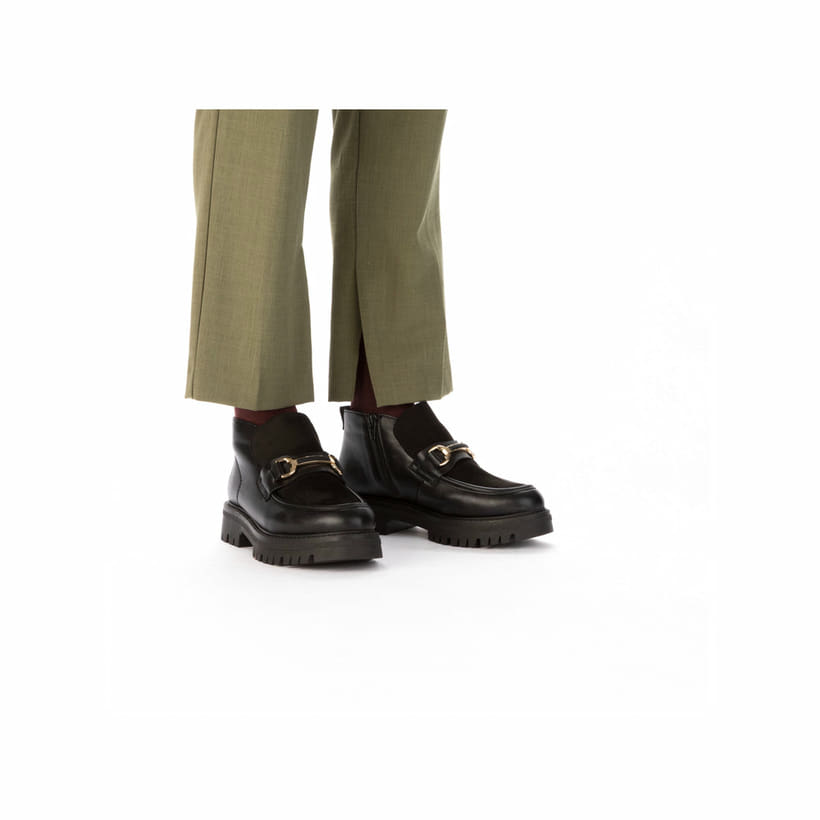 Schwarze Rieker Damen Kurzstiefel 47582-00 mit Deko-Kette sowie Reißverschluss. Schuh am Fuß.