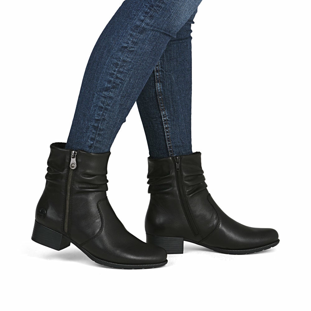 Schwarze Rieker Damen Stiefeletten 78656-00 aus Glattleder mit Reißverschluss. Schuh am Fuß.
