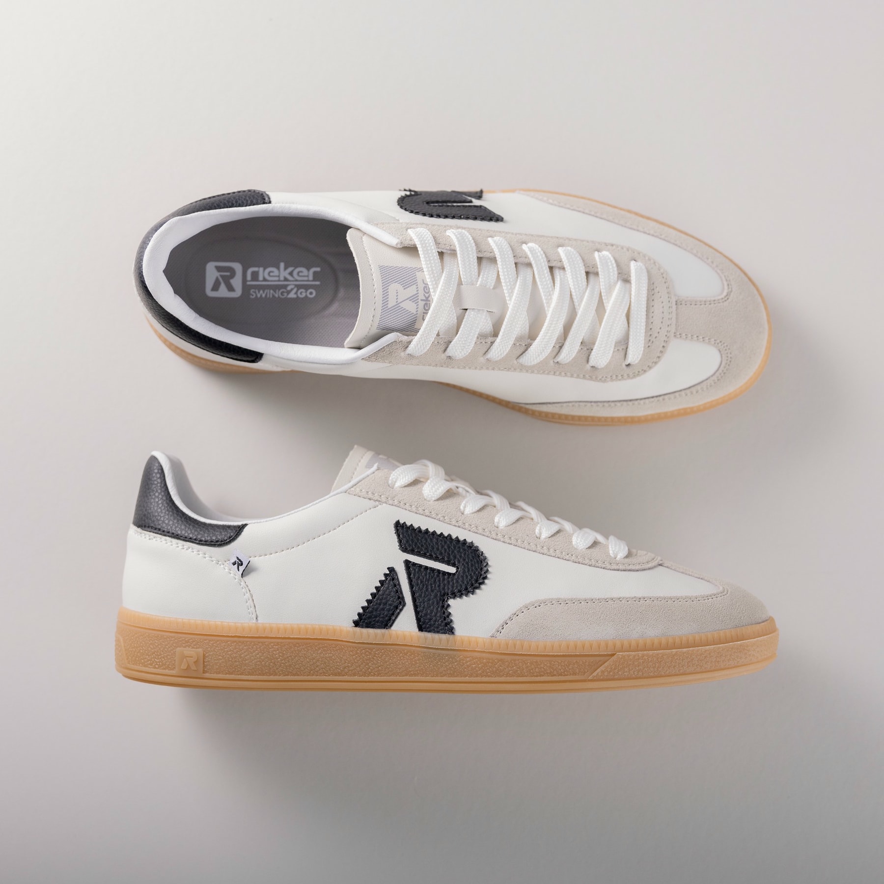 Weiße Rieker Herren Sneaker Low U2200-83 mit einer Schnürung. Schuhpaar von oben, seitlich auf grauem Hintergrund.