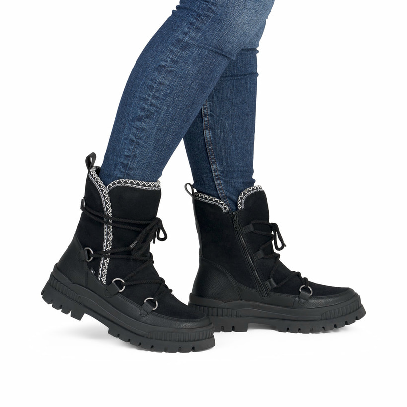 Schwarze Rieker Damen Kurzstiefel W2175-00 aus Rauleder mit weißer Zickzack-Naht. Schuh am Fuß.