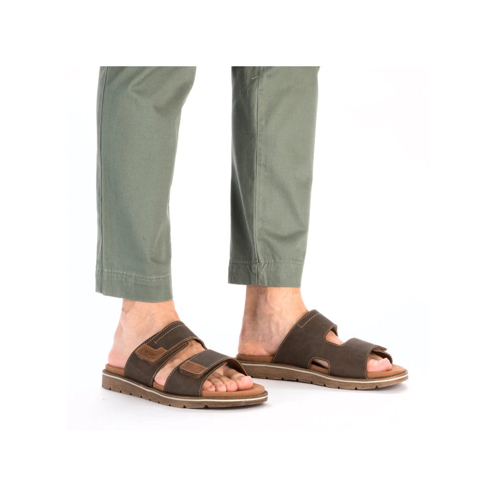 Braune Rieker Herren Pantoletten 24394-25 mit modernen Ziernähten. Schuh am Fuß.