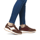 Braune Rieker Damen Sneaker Low W0607-35 mit griffiger Sohle sowie Schnürung. Schuh am Fuß.