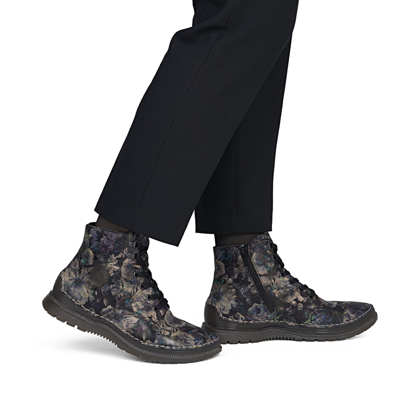 Schwarze Rieker Damen Schnürstiefel 53632-90 mit floralem Aufdruck. Schuh am Fuß.