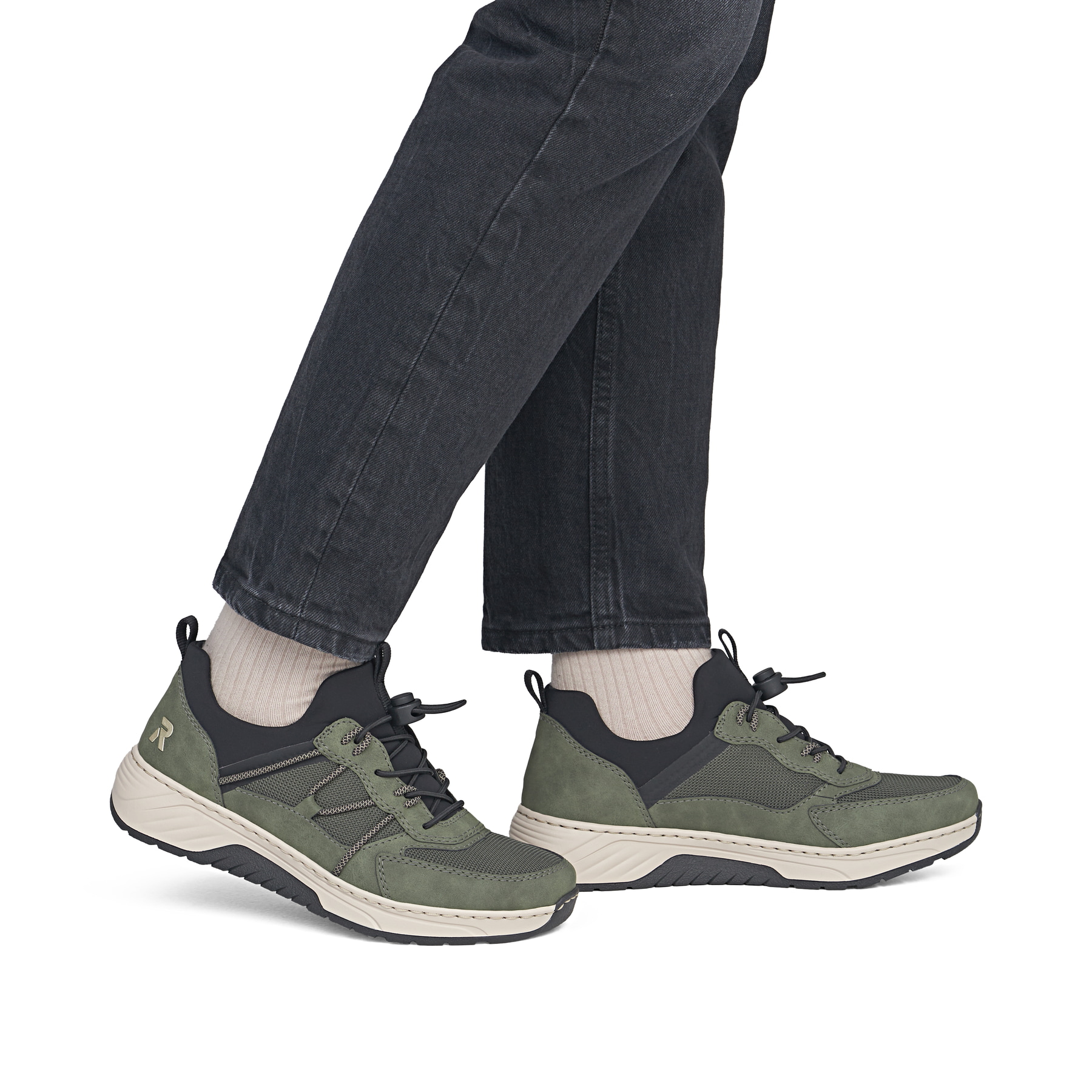 Khaki-schwarze Rieker Damen Slipper 53153-54 mit Gummizug sowie der Extraweite H. Schuh am Fuß.