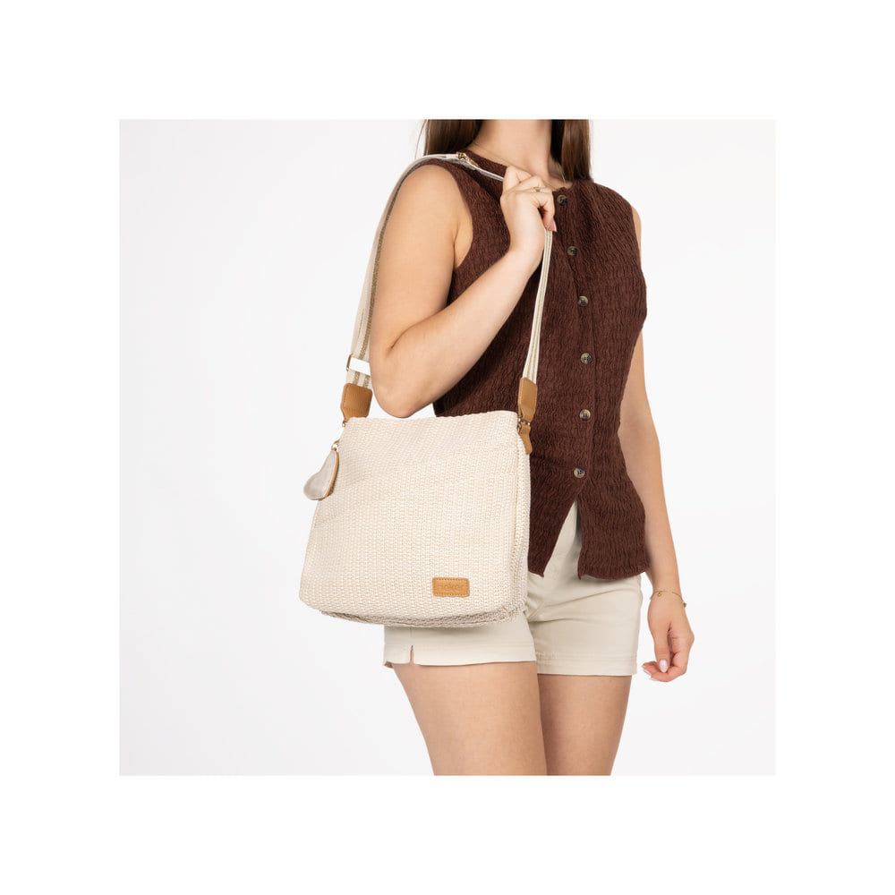 Sac à bandoulière Rieker H1004-62 beige avec fermeture éclair et pendentif en forme de cœur amovible. Porté.