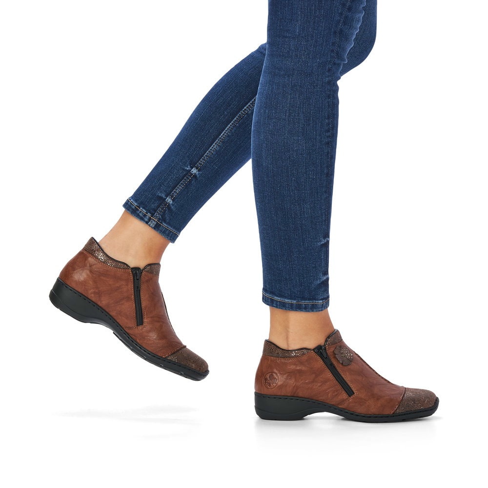 Braune Rieker Damen Kurzstiefel 58388-22 aus Glattleder mit Leo-Print. Schuh am Fuß.