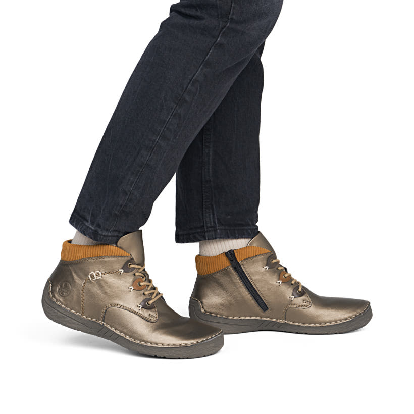 Bronzefarbene Rieker Damen Kurzstiefel 52544-90 mit einem Reißverschluss. Schuh am Fuß.