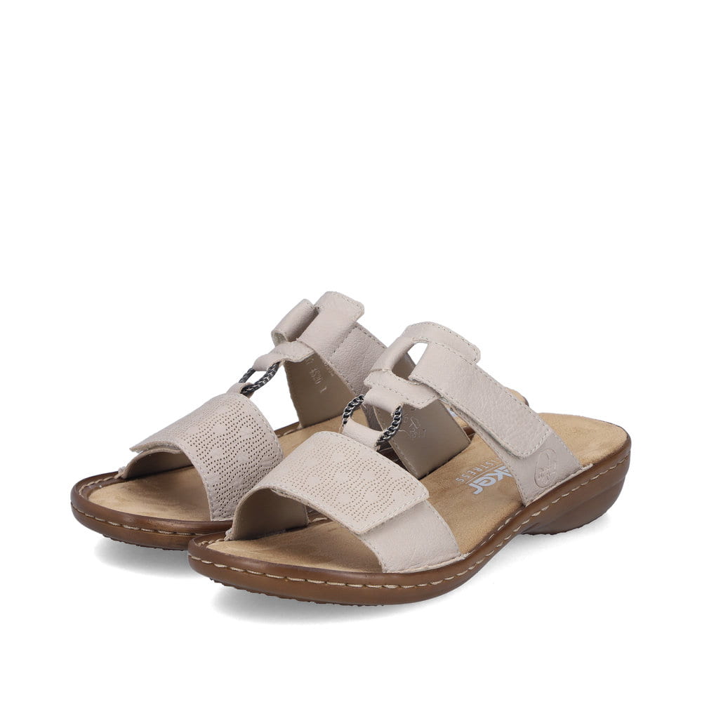 Beige Rieker Damen Pantoletten 60885-62 mit Schmuckelementen. Schuhpaar seitlich schräg.