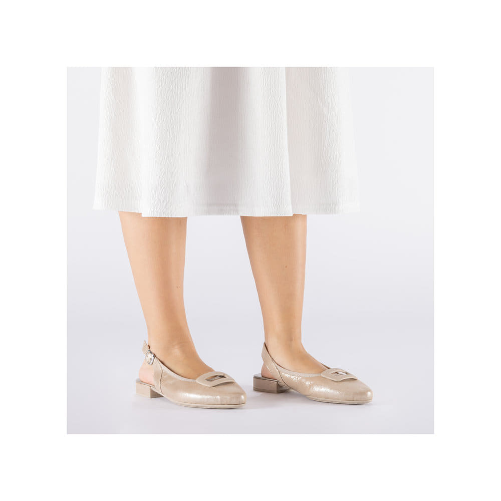 Beige Rieker Slingpumps 43150-60 mit Schnallen sowie einer leichten Sohle. Schuh am Fuß.