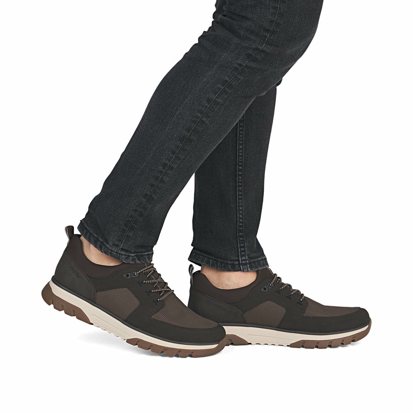 Braune Rieker Herren Slipper B9351-25 mit einem Gummizug sowie der Extraweite H. Schuh am Fuß.
