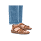 Braune Rieker Damen Riemchensandalen 60809-24 mit einem Gummizug. Schuh am Fuß.