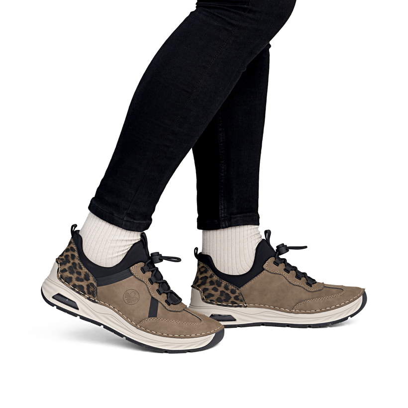 Braun-schwarze Rieker Damen Slipper 44551-24 mit Rieker Air Sohlenfenster. Schuh am Fuß.