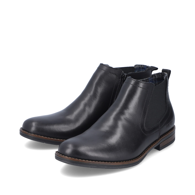 Nachtschwarze Rieker Herren Chelsea Boots 10374-00 mit einer robusten Profilsohle. Schuhpaar schräg.