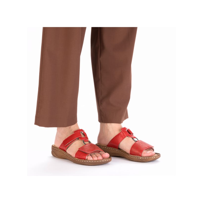 Rote Rieker Damen Pantoletten V2885-33 in Löcheroptik mit einem Klettverschluss. Schuh am Fuß.