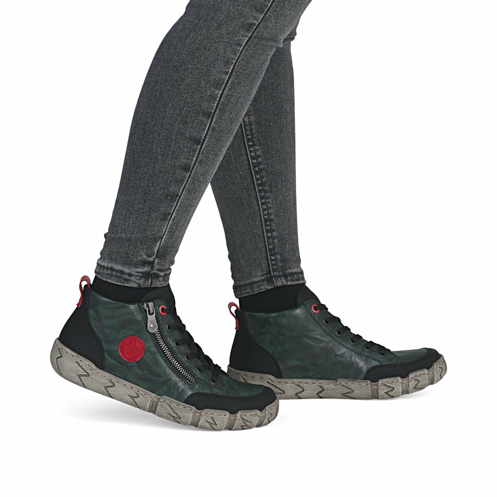 Grünschwarze Rieker Damen Kurzstiefel L0306-54 aus Glattleder mit rundem Logo. Schuh am Fuß.