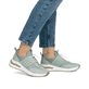 Grüne Rieker Damen Sneaker Low M6651-52 mit einem Gummizug sowie Extraweite H. Schuh am Fuß.