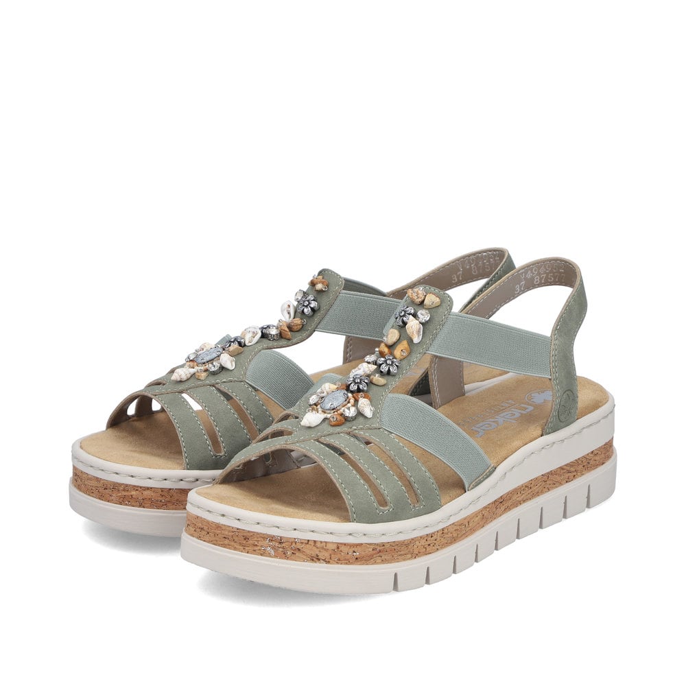 Sandales compensées Rieker vertes femme V4949-52 avec éléments décoratifs. Chaussures inclinées sur le côté.