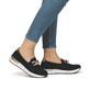 Schwarze Rieker Damen Loafer 58944-00 mit Deko-Kette sowie einem Gummizug. Schuh am Fuß.