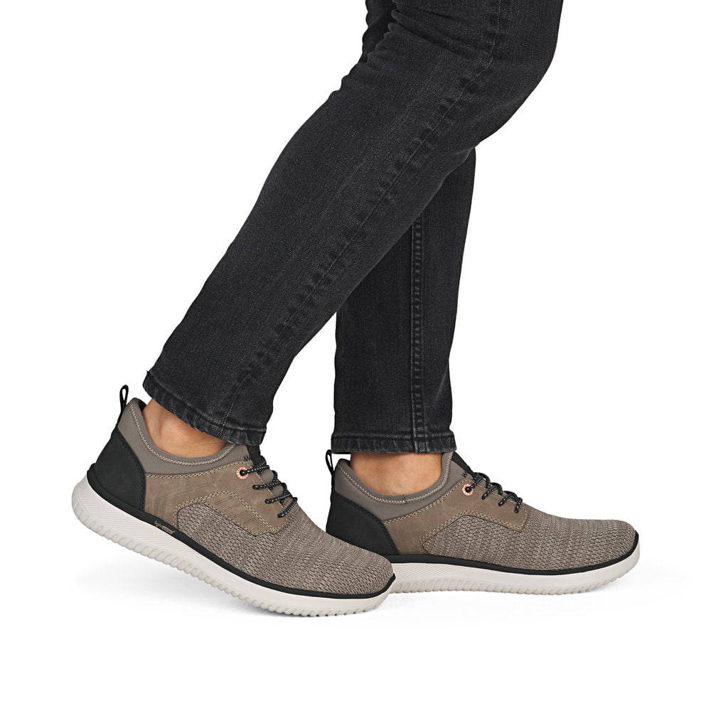 Beige Rieker Herren Slipper B9651-64 mit einem Gummizug sowie der Komfortweite G. Schuh am Fuß.
