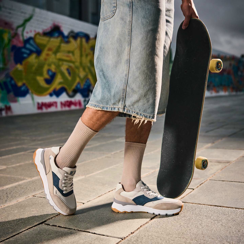 Beige Rieker Herren Sneaker Low U0906-81 mit Schnürung sowie flexibler Sohle. Schuh am Model.