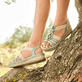 Grüne Rieker Keilsandaletten V0920-52 mit Schmuckelementen sowie einem Gummizug. Schuh am Model.