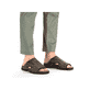 Braune Rieker Herren Pantoletten 25093-25 mit Elastikeinsatz sowie Ziernähten. Schuh am Fuß.