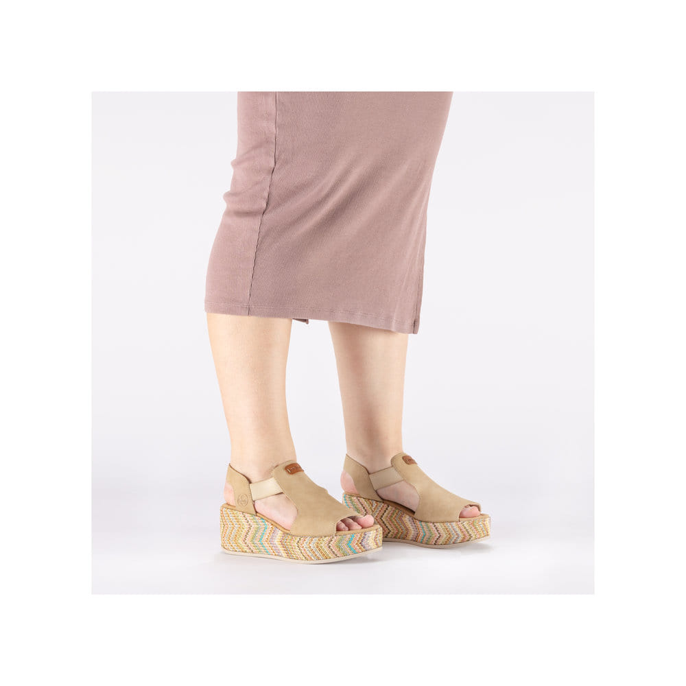 Beige Rieker Keilsandaletten 69472-60 mit Gummizug sowie leichter Plateausohle. Schuh am Fuß.